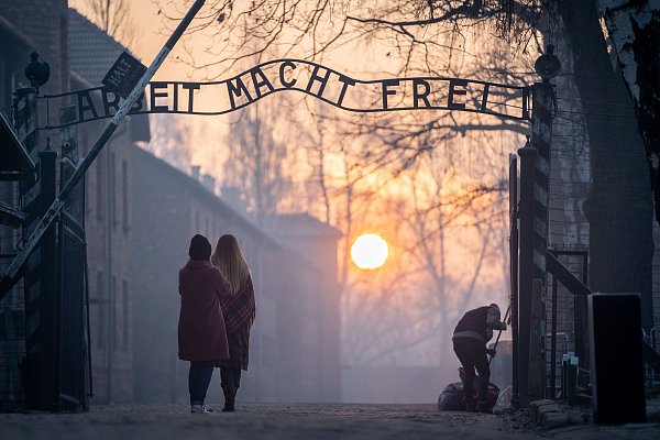 Besucher stehen am Tor zum ehemaligen Konzentrationslager Auschwitz I mit dem Schriftzug "Arbeit macht frei". - © dpa