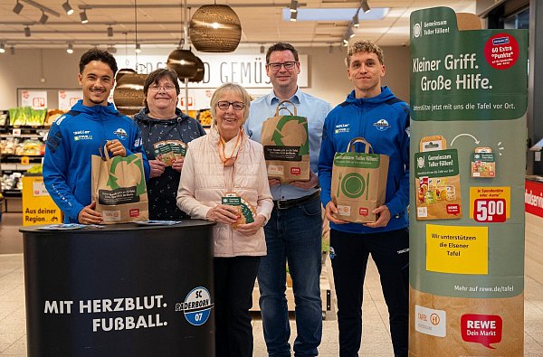 (von links) SCP-Profi Mika Baur, Monika Hachmeier und Gertrudis Rauhut von der Tafel-Ausgabestelle Paderborn-Elsen, Filialleiter Daniel Saal und SCP-Kicker Luca Herrmann bei der Tafeltüten-Aktion im Elsener Rewe-Markt. - © SC Paderborn 07