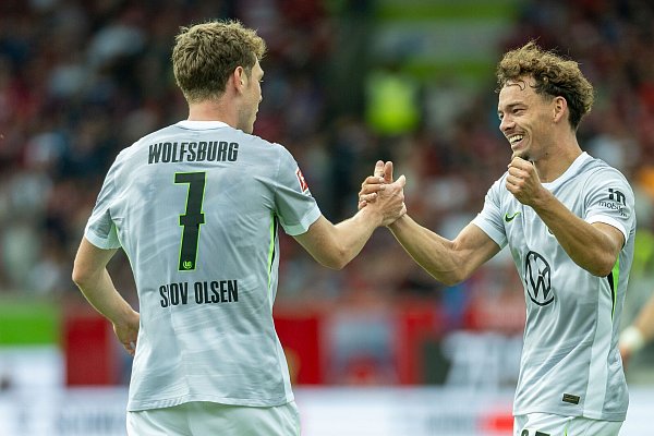 Aaron Zehnter (r.) jubelt mit dem Torschützen Andreas Skov Olsen, der den VfL Wolfsburg beim Auftaktspiel in Heidenheim mit 1:0 in Führung brachte. - © Picture Alliance