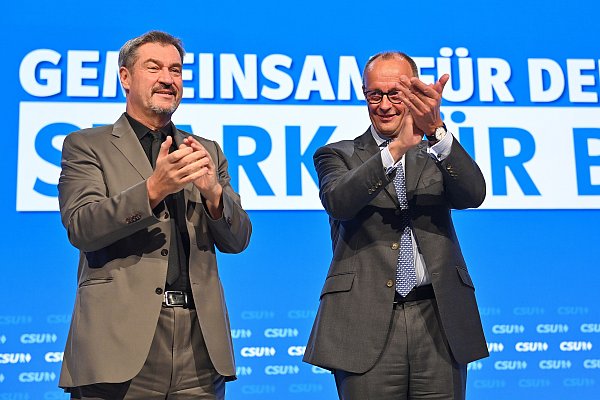 CSU-Chef Markus Söder und CDU-Chef Friedrich Merz stehen auf der anderen Seite. - © picture alliance / SvenSimon