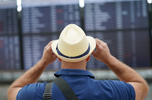 Ein Reisender studiert die Anzeigetafel am Flughafen: Für Last-Minute-Schnäppchen braucht es oft Flexibilität. - © Marcus Brandt/dpa