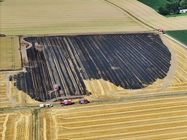 Feuerwehrfahrzeuge am Rand eines abgebrannten Felds in Holsen. - © Gerald Dunkel