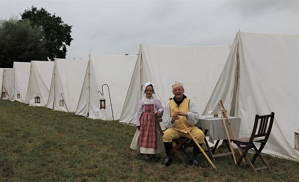 Der Herr Major Matthias Michaler und die siebenjährige Pauline vor einer Zeltreihe im Lager. - © Simone Flörke