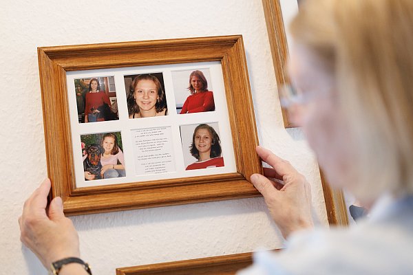 Ingrid Liebs steht in ihrem Haus vor einem Bilderrahmen mit Fotos ihrer Tochter Frauke, die vor 17 Jahren ermordet wurde. - © Friso Gentsch / dpa