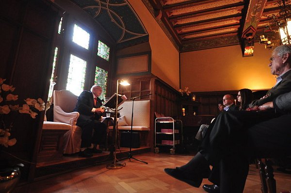 Im historischen Burgsaal liest Walter Strümper in einem Ohrensessel sitzend aus seinem Buch vor.