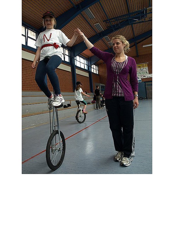 Nele (l.) übt mit Unterstützung von Mareike Westerhold das Fahren auf dem großen Einrad. - © FOTO: JEANNINE GEHLE