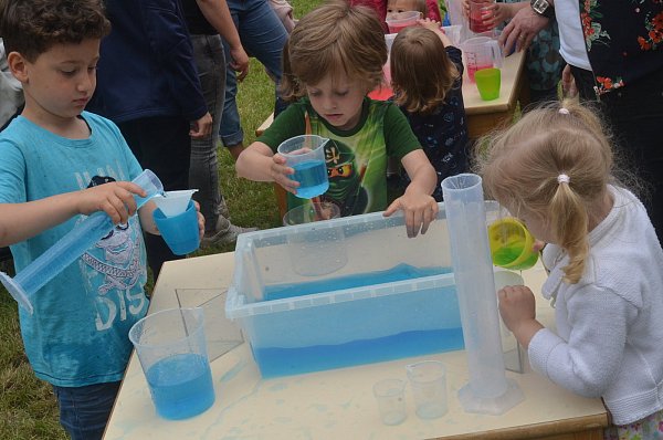 Drei junge Forscher haben blau gefärbtes Wasser zu ihrem Spielelement erkoren. - © Dietmar Gröbing