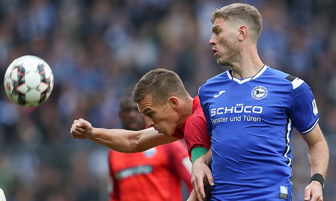 Vereinslegenden unter sich: Bielefelds Fabian Klos (r.) kommt im Kampf um den Ball mit Uwe Hünemeier (l.) aus Paderborn zu spät. - picture alliance/dpa