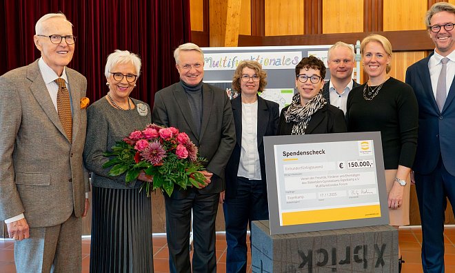 Dietmar und Margrit Harting (l.) sowie Philip Harting und Maresa Harting-Hertz (r.) überreichten den symbolischen Spendenscheck in Höhe von 150.000 Euro an Schulleiterin Marie-Luise Schellong (4.v.r.) und deren Vertreterin Ulrike Salge (4. v. l.) vom Söderblom-Gymnasium. Die Übergabe fand im Beisein von Espelkamps Bürgermeister Henning Vieker (3. v. r.) und Ralf H. Krause (3. v. l.), Oberkirchenrat und Finanzdezernent der Evangelischen Kirche von Westfalen, statt. - Harting