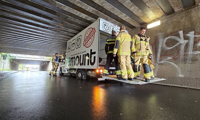 Einsatzkräfte der Bünder Feuerwehr stehen auf der geöffneten Laderampe des Lkw, um noch mehr Luft zwischen Fahrzeug und Brück zu schaffen. Auch die Luft wurde schon aus den Reifen gelassen. - Gerald Dunkel