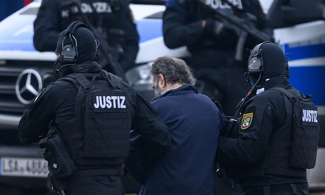 Der Angeklagte wird von Justizpersonal nach der Landung im Hubschrauber in Magdeburg zur Fahrzeugkolonne geführt. - Hendrik Schmidt/dpa