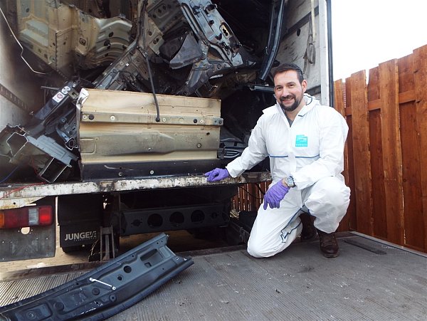 Kriminaloberkommissar Phil Clark untersucht einen Lastwagen, der mit Teilen von drei BMW X-Modellen zum Abtransport beladen war. - © Polizei Paderborn