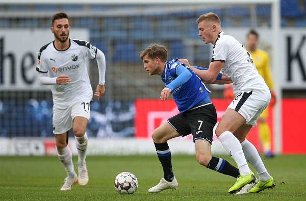 Arminias Patrick Weihrauch (M) im Kampf um den Ball mit Fabian Schleusener (l) und Aleksandr Zhirov (r) aus Sandhausen. - © picture alliance/dpa