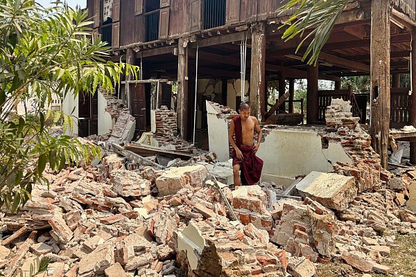 Ein buddhistischer Mönch steht in den Trümmern eines beschädigten Gebäudes in einer Klosteranlage in Myanmar. - © Aung Shine Oo/AP/dpa