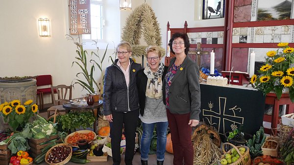 Vor dem festlich geschmückten Altarraum: Dorothea Grote, Petra Wederhake und Renate Firker. - © Privat
