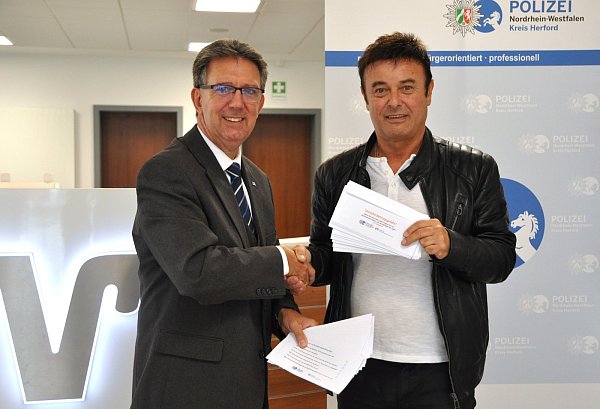 Volksbank-Marketingleiter Andreas Kelch und Kriminalhauptkommissar Rainer Böker von der Kreispolizeibehörde stellen den neuen Geldumschlag mit Warnhinweisen zum „Enkeltrick"-Betrug vor. - © Volksbank