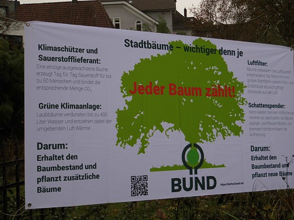 Ein Transparent zwischen den Bäumen neben dem Daniel-Pöppelmann-Haus soll auf deren Nutzen hinweisen. - © Matthias Bungeroth