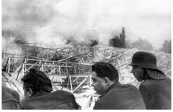 Feuerwehrmänner schauen sich die zerstörte Eisenkonstruktion des Vossen-Werkes an, das damals die größte Frottierweberei Europas war und allein in Gütersloh 2.800 Mitarbeiter beschäftigte. - © FOTO: STADTARCHIV GÜTERSLOH