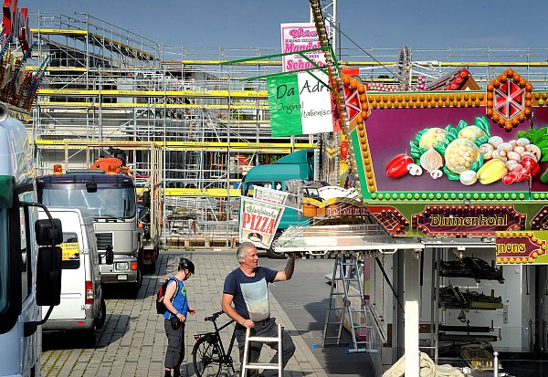 Aufbau: Die ersten Buden stehen schon. In diesem Jahr müssen die Besucher und die Betreiber der Fahrgeschäfte und Imbissbuden mit dem Blick auf die Baustelle der neuen Rettungs- und Feuerwache (Hintergrund) leben. - © Andreas Fruecht
