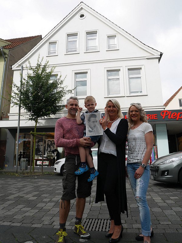 Mitten in Bünde: Michael, Linus, Renate und Tina Rose mit einem Bild Walter Bäumers. Als neue Besitzer ließen sie das ehemalige Elternhaus des Rennfahrers wieder in altem Glanz erstrahlen und stießen dabei auf die Geschichte des Rennfahrers. - © Militzer