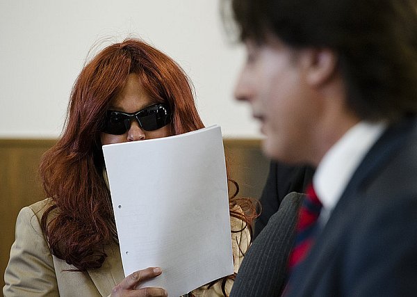 Heidi K. Verbirgt sich hinter Sonnennbrille, Papier und einer Rothaar-Perücke. - © FOTO: DPA