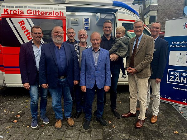 Thomas Kuhlbusch (v.l), Dezernent, Kreis Gütersloh, Detlef Vincke Überlebender, Ralf Stroop, Entwickler und Ideengeber, Andreas Lekic, Überlebender, Heinrich Harbrock, Überlebender, Alexander Bloch, Überlebender, und Bernd Strickmann, Ärztlicher Leiter des kreiseigenen Rettungsdienstes, feiern gemeinsam mit Landrat Sven-Georg Adenauer (2.v.r.) vor dem Kreishaus. - © Danielle Dörsing