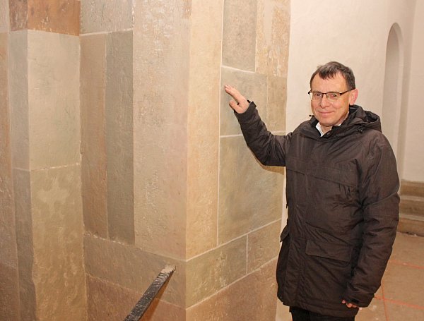 Unter dem Putz aus der Nachkriegszeit ist der ursprüngliche Sandstein relativ gut erhalten geblieben. Er gibt der Vorhalle jetzt ein anderes Gesicht, findet Pfarrer Eckhard Düker. - © EKP/Oliver Claes