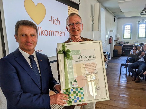 Landrat Michael Stickeln überbringt Stiftungsvorstand Johann von der Borch eine Ehrenurkunde. - © Burkhard Battran