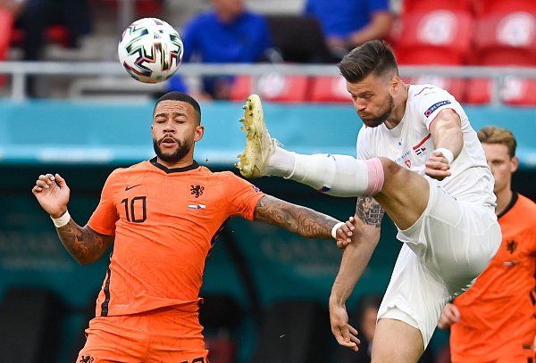 Der Tscheche Ondrej Celustka geht mit gestrecktem Bein ins Duell mit Memphis Depay. - © Robert Michael/dpa-Zentralbild/dpa