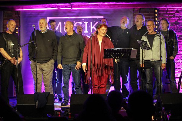 Harmonischer Sängerwettstreit: Zu "Wild Mountain Thyme" fanden sich die Gäste mit Sangeslust auf der Bühne ein. Ganz in Rot Lea Moses, die ehemalige Wirtin des Gallows Folk Club. - © Foto: Hagen